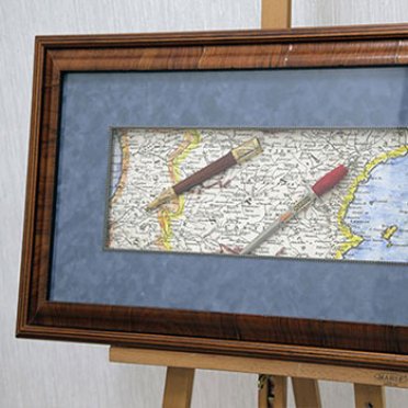 Старинный кинжал и карта в багетной раме под стеклом